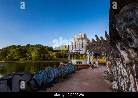 Parco acquatico abbandonato Thuy Tien Lake a Hue, Vietnam. Splendido paesaggio della giungla che supera l'architettura. Foto Stock