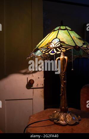 Una lampada Art Nouveau con paralume in vetro tinto stile Tiffany che crea splendide ombre. --- un fine settimana a Brooklyn House, Martham Foto Stock