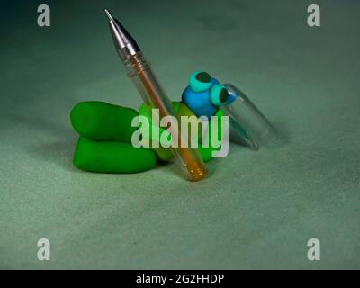Penna in terra di argilla di colore verde con guscio in terra distesa sul pavimento con relax Foto Stock