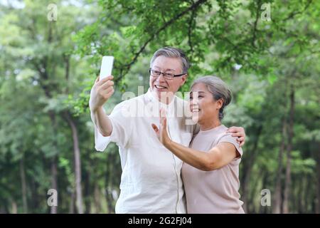 Felice vecchia coppia prendere selfie con telefono cellulare in parcheggio foto di alta qualità Foto Stock