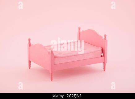 Letto in miniatura di legno rosa su sfondo rosa Foto Stock