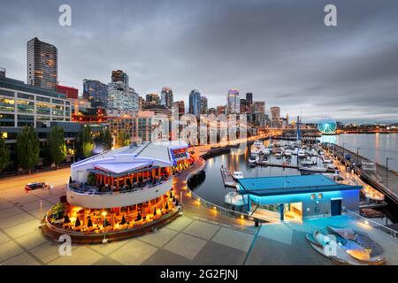 Seattle, Washington, Stati Uniti d'America pier e sullo skyline al tramonto. Foto Stock
