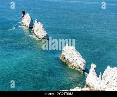 Gli aghi pile di gesso e il faro degli aghi che sorvegliano il Solent nel punto occidentale dell'Isola di Wight UK Foto Stock