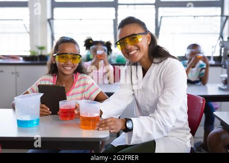 Ritratto di un'insegnante e una ragazza afro-americana sorridente durante la lezione di scienza in laboratorio Foto Stock