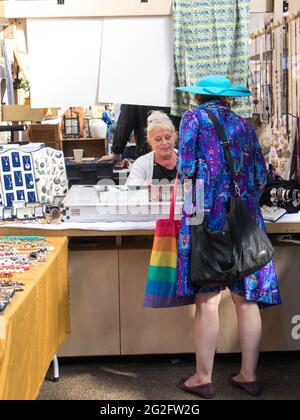 Liverpool Street, Londra, Regno Unito, 21 settembre 2020, mercato dell'antiquariato di Spitalfields. Donna in abito blu e cappello di paglia con borsa dipinta in colori arcobaleno ch Foto Stock