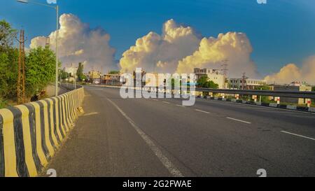25 maggio 2021 - Reengus, Sikar, India. Impressionante scatto di strada con barriera di sicurezza in metallo o rotaia. Auto sull'asfalto sotto il cielo nuvoloso. Foto Stock