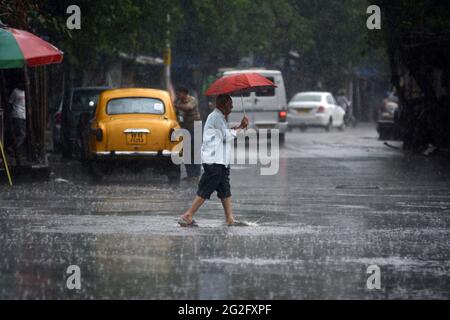 Kolkata, Bengala Occidentale, India. 11 Giugno 2021. Un uomo attraversa una strada durante forti precipitazioni a Kolkata, in India. Credit: Aditya/ZUMA Wire/Alamy Live News Foto Stock