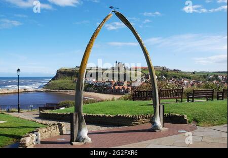 Un arco fatto di jawbones balena a Whitby, North Yorkshire UK. La costa del Mare del Nord e l'abbazia di Whitby sono visibili nell'immagine. Foto Stock