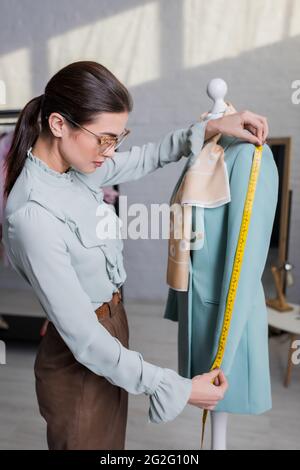 Manica di misura Seamstress di giacca su manichino Foto Stock