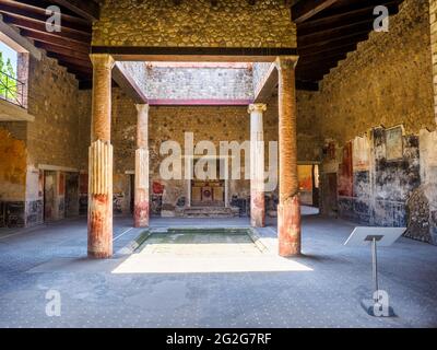 Atrio in stile tetraidro con quattro colonne ioniche intorno ad un impianto centrale. L'atrio è decorato nel quarto stile con pannelli rossi, neri e gialli Foto Stock