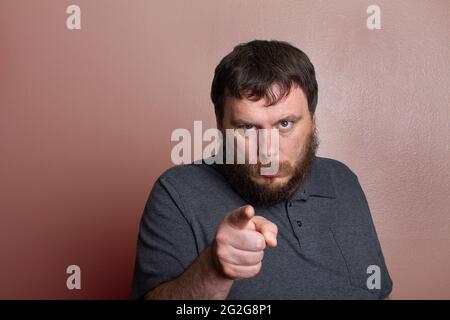 Uomo che indica la sua figura con uno sguardo arrabbiato sul viso Foto Stock