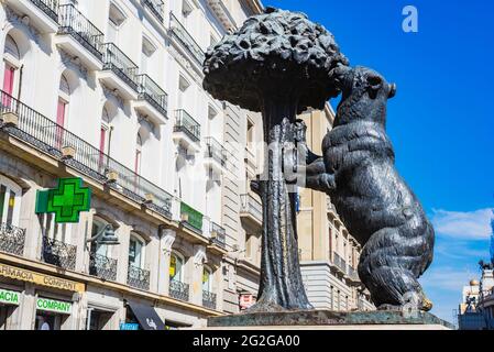 Statua in bronzo dell'Orso e dell'albero Madroño, albero di fragole, simbolo araldico di Madrid. La Puerta del Sol, porta del Sole, è una piazza pubblica di Mad Foto Stock