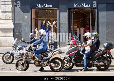 Milano, Italia - 20 luglio 2020. Spostamenti in moto. Uomo in maschera a cavallo moto in trafficato traffico cittadino di strada. Motociclista guida la motocicletta sul Foto Stock