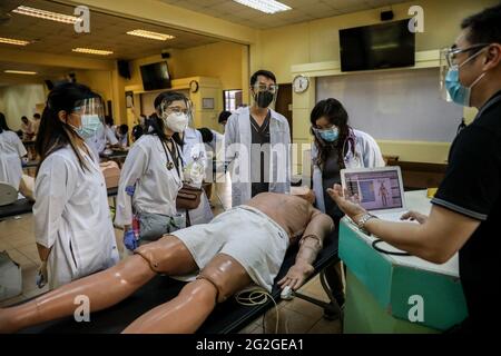 Manila, Filippine. 10 Giugno 2021. Gli studenti di medicina svolgono un esercizio di competenze cliniche su un manichino elettronico durante una lezione faccia a faccia all'Università di Santo Tomas. L'università ha iniziato le sue classi faccia a faccia limitate dopo che il governo ha permesso la ripresa della formazione pratica e delle classi di laboratorio nei campus, osservando i protocolli sanitari per prevenire la diffusione della malattia del coronavirus. Foto Stock