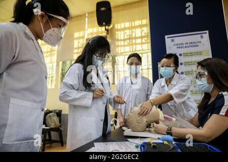 Manila, Filippine. 10 Giugno 2021. Gli studenti di medicina eseguono un'intubazione endotracheale su un manichino durante una lezione faccia a faccia all'Università di Santo Tomas. L'università ha iniziato le sue classi faccia a faccia limitate dopo che il governo ha permesso la ripresa della formazione pratica e delle classi di laboratorio nei campus, osservando i protocolli sanitari per prevenire la diffusione della malattia del coronavirus. Foto Stock