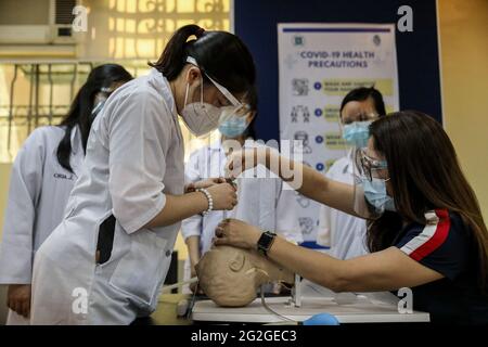 Manila, Filippine. 10 Giugno 2021. Gli studenti di medicina eseguono un'intubazione endotracheale su un manichino durante una lezione faccia a faccia all'Università di Santo Tomas. L'università ha iniziato le sue classi faccia a faccia limitate dopo che il governo ha permesso la ripresa della formazione pratica e delle classi di laboratorio nei campus, osservando i protocolli sanitari per prevenire la diffusione della malattia del coronavirus. Foto Stock