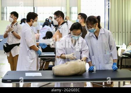 Manila, Filippine. 10 Giugno 2021. Gli studenti di medicina si preparano a frequentare una lezione faccia a faccia all'Università di Santo Tomas. L'università ha iniziato le sue classi faccia a faccia limitate dopo che il governo ha permesso la ripresa della formazione pratica e delle classi di laboratorio nei campus, osservando i protocolli sanitari per prevenire la diffusione della malattia del coronavirus. Foto Stock