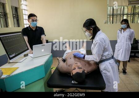 Manila, Filippine. 10 Giugno 2021. Gli studenti di medicina svolgono un esercizio di competenze cliniche su un manichino elettronico durante una lezione faccia a faccia all'Università di Santo Tomas. L'università ha iniziato le sue classi faccia a faccia limitate dopo che il governo ha permesso la ripresa della formazione pratica e delle classi di laboratorio nei campus, osservando i protocolli sanitari per prevenire la diffusione della malattia del coronavirus. Foto Stock