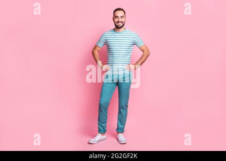 Vista di dimensioni del corpo di lunghezza completa di piacevole attraente contenuto allegro ragazzo mani su fianchi isolati su sfondo rosa colore pastello Foto Stock