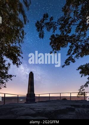 Obelisco storico sotto il cielo stellato con la Via Lattea sul Lilienstein nelle montagne di pietra arenaria dell'Elba. Foto Stock