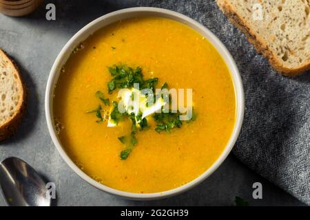 Zuppa di lenticchie di carota sana fatta in casa con prezzemolo e panna acida Foto Stock