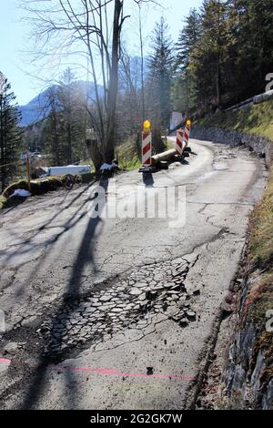 Accesso al cantiere, danni alla strada nel pavimento di catrame di una strada vicino a Mittenwald, sole, luce posteriore, cantiere, accesso all'hotel, Trasporti pesanti, Europa, Germania, Baviera, alta Baviera, Mittenwald, Werdenfelser Land, valle dell'Isar Foto Stock