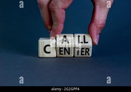 Simbolo del call center. Uomo d'affari trasforma i cubetti di legno con le parole 'Call center'. Splendido sfondo grigio. Call center e concetto aziendale. Spazio di copia. Foto Stock