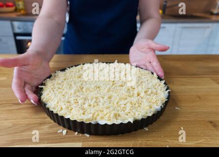 Torta di yogurt crudo da pasta cosparsa di foglie di menta su un vassoio pronto per cucinare Foto Stock