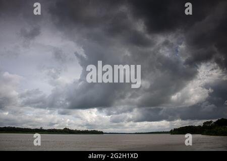 Cielo nuvoloso. Spesse nuvole nere sul petto del fiume. Il cielo nuvoloso si fuse con il fiume. Foto Stock