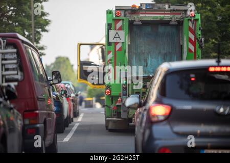 Huerth, NRW, Germania, 06 09 2021, i camion dei rifiuti stanno bloccando il passaggio in una strada, le automobili stanno attendendo dietro di esso Foto Stock