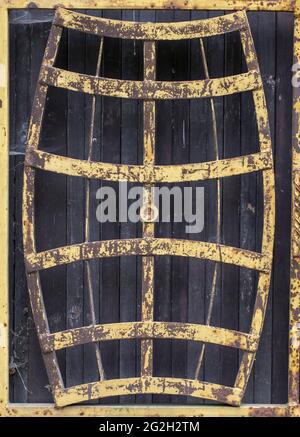 Porta vecchia con porta in metallo arrugginito a forma di botti di vino. Lucchetto e abbandonato. Foto Stock