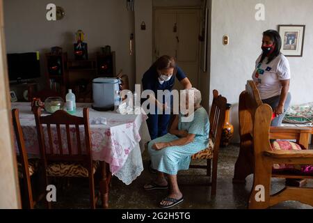 Caracas, Venezuela. 11 Giugno 2021. Un operatore sanitario somministra una prima dose del vaccino corona Sputnik V ad una donna anziana a casa sua. Secondo il Ministero della Salute, 247,847 sono stati infettati con Covid-19 a livello nazionale. Il tasso di mortalità è ufficialmente del 1.12%. Credit: Pedro Rances Mattey/dpa/Alamy Live News Foto Stock