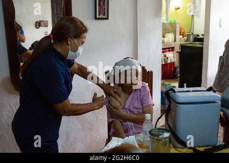 Caracas, Venezuela. 11 Giugno 2021. Un operatore sanitario somministra la prima dose del vaccino corona Sputnik V ad una donna anziana a casa sua. Secondo il Ministero della Salute, 247,847 sono stati infettati con Covid-19 a livello nazionale. Il tasso di mortalità è ufficialmente del 1.12%. Credit: Pedro Rances Mattey/dpa/Alamy Live News Foto Stock