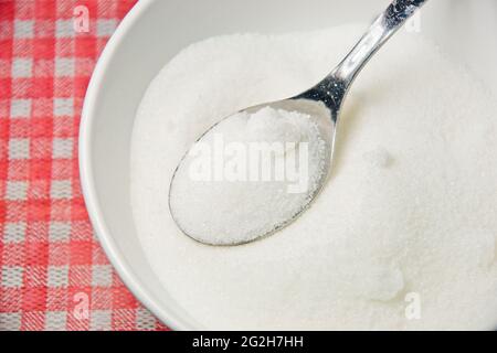 Primo piano di una ciotola di zucchero con cucchiaio di metallo Foto Stock