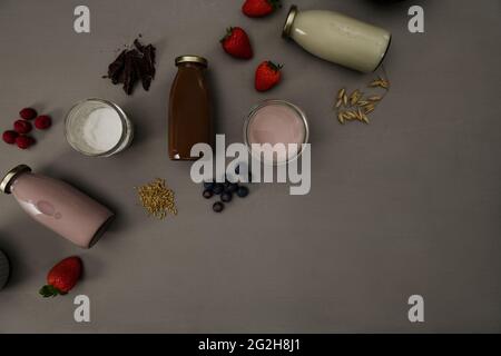 Latte di avena, cioccolato, bacche, frullato, spighe di frumento, vista dall'alto Foto Stock