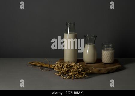 Latte di avena, piatto, orecchio di frumento, bottiglia di latte, caraffa, vaso mason Foto Stock
