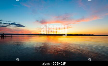 Il sole tramonta su Puget Sound nello stato occidentale di Washington creando uno sfondo di forme rosa e arancione nel cielo serale. Foto Stock
