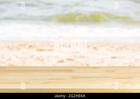 tavolo in legno sulla spiaggia di mare sfocata con conchiglie sfondo Foto Stock