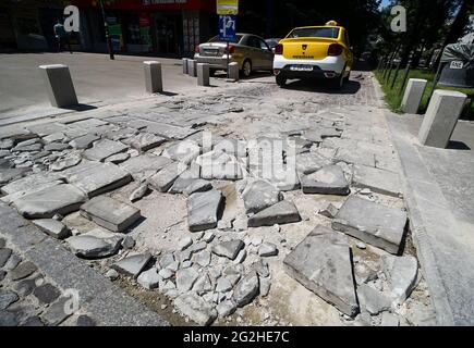 Bucarest, Romania - 06 giugno 2021: Un taxi ha appena superato le pietre spezzate di un marciapiede, nel centro di Bucarest. Foto Stock