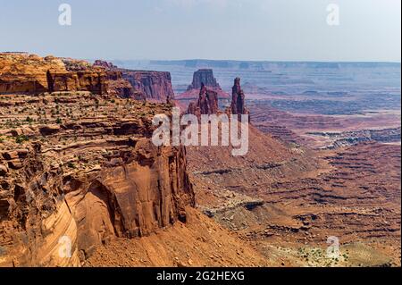 Mesa Arch. Arco in arenaria a picco sulla scogliera che incornicia un'iconica vista dell'alba del paesaggio sottostante del canyon di roccia rossa. Canyonlands National Park, Utah, Stati Uniti Foto Stock