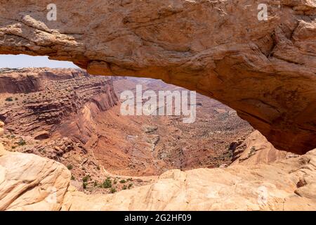 Mesa Arch. Arco in arenaria a picco sulla scogliera che incornicia un'iconica vista dell'alba del paesaggio sottostante del canyon di roccia rossa. Canyonlands National Park, Utah, Stati Uniti Foto Stock