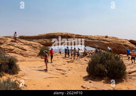 Mesa Arch. Arco in arenaria a picco sulla scogliera che incornicia un'iconica vista dell'alba del paesaggio sottostante del canyon di roccia rossa. Canyonlands National Park, Utah, Stati Uniti Foto Stock