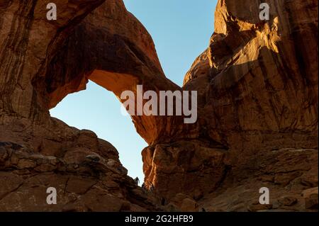 Il famoso Double Arch - una formazione di arenaria e popolare luogo fotografico con due grandi archi che si spriggono dalla stessa fondazione laterale - noto per le campate anteriori e posteriori nel Parco Nazionale di Arches, vicino a Moab nello Utah, USA Foto Stock