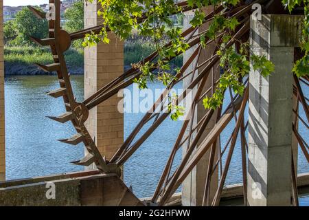Primo piano di un vecchio mulino ad acqua costruito di fronte ad un lago Foto Stock