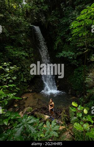 Giovane donna alla cascata nel Parco delle Cascate di Mc Laren, Bay of Plenty District, North Island, Nuova Zelanda Foto Stock