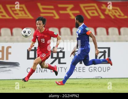 Sharjah. 12 giugno 2021. Yin Hongbo (L) della Cina si rompe dopo Akram Abdull Gani delle Maldive durante la loro partita del Gruppo A alla Coppa del mondo FIFA Qatar 2022 e AFC Asian Cup Cina 2023, Qualifiche congiunte preliminari a Sharjah, gli Emirati Arabi Uniti (UAE), 11 giugno 2021. Credit: Xinhua/Alamy Live News Foto Stock