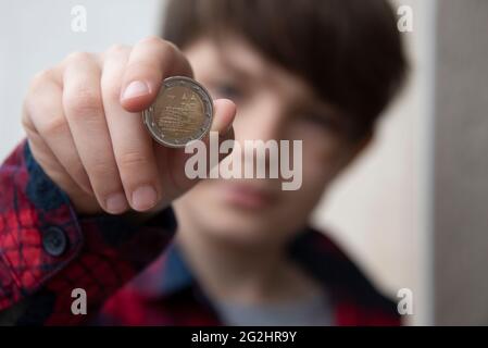 Germania, Sassonia-Anhalt, Magdeburgo, ragazzo tiene una moneta da 2 euro con la Cattedrale di Magdeburgo in mano. Foto Stock