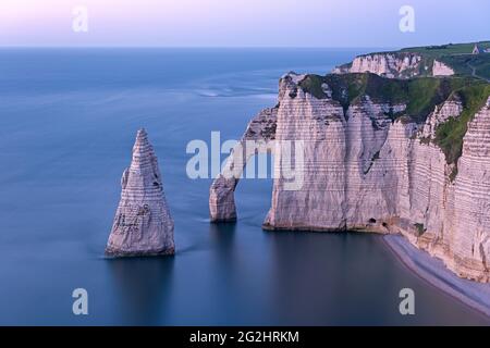 Chalk costa vicino a Etretat, Porte d'Aval rock gate e Aiguille d'Etretat rock ago, umore sera, Francia, Normandia, dipartimento Senna Marittima Foto Stock