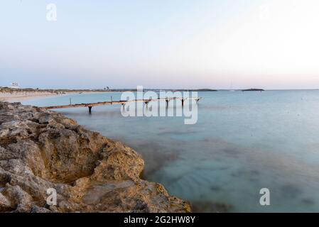 Molo nella spiaggia deserta di Ses Illetes sull'isola di Formentera in Spagna. Foto Stock