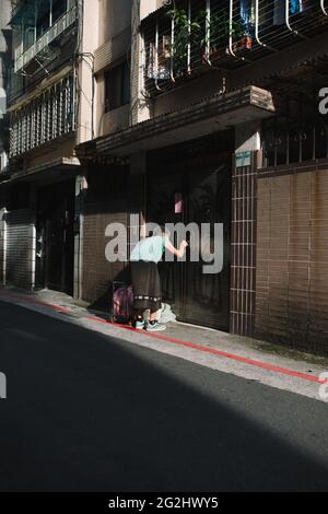 Taipei, Taiwan - 2 luglio 2018: Donna torna a casa dopo aver fatto acquisti al mercato. Foto Stock